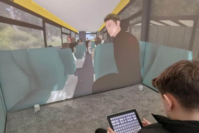 A child operating the Blue Room, with a scenario on screen showing a view of inside a bus, helping overcome fear of using public transport. Pic: Third Eye NeuroTech/Newcastle University/PA Wire.