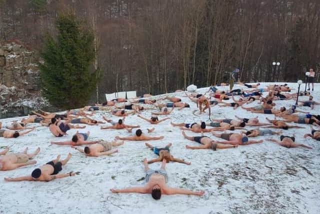 The course members lie in the snow as they learn about the Wim Hof Method.
