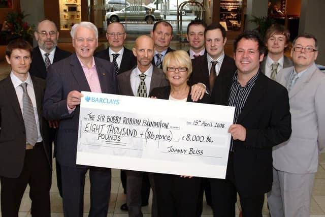 Sir Bobby with Johnny Bliss, centre, as Johnny's family presented cash to the Sir Bobby Robson Foundation.