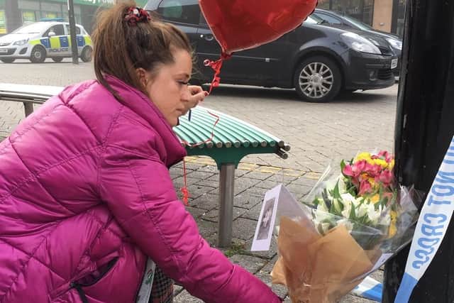 Adele Dawson lays flowers in memory of friend Connor Brown after his death.