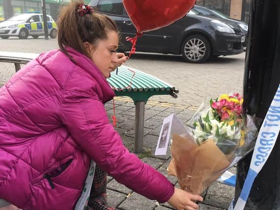 Adele Dawson lays flowers in memory of friend Connor Brown after his death.