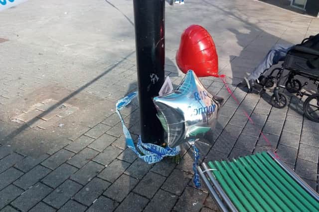 A silver, star-shaped balloon with the message 'RIP Connor' has been left at the scene, along with flowers.