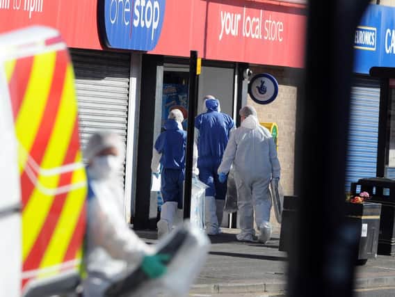 Police officers at the One Stop shop where Joan Hoggett was stabbed to death.