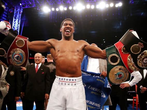 Anthony Joshua proudly presents his world championship belts to the crowd after his last win over Alexander Povetkin.