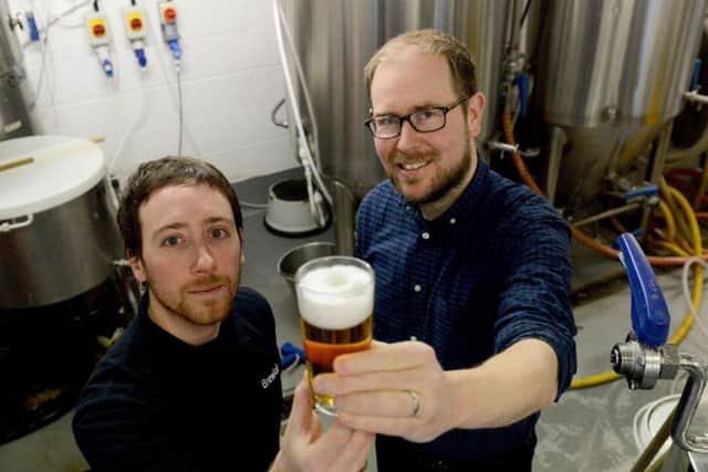 From left, Brewlab project and brewing assistant Julio Romero Johnson examines one of the new beers with Vaux Brewery managing director Steven Smith.