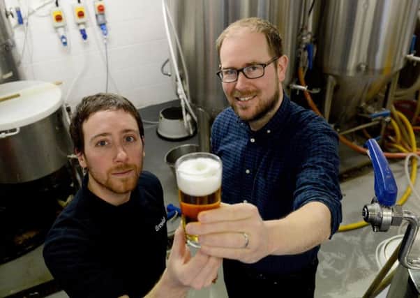 From left, Brewlab project and brewing assistant Julio Romero Johnson examines one of the new beers with Vaux Brewery managing director Steven Smith.