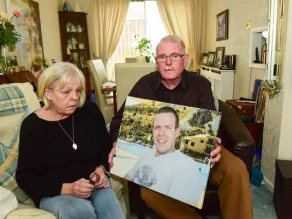 Linda and Dan Golden with a photograph of late dead Frazer.