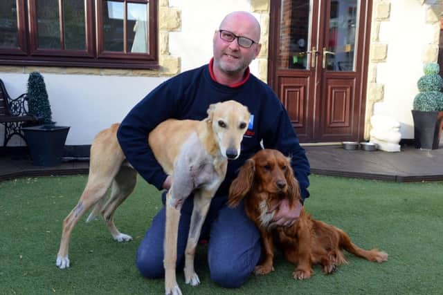 Stephen Turner with his lurcher Red, who was injured on a post at Castletown Dene, and the family's cocker spaniel Max.