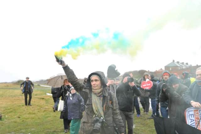 A woman lets off blue and yellow flares