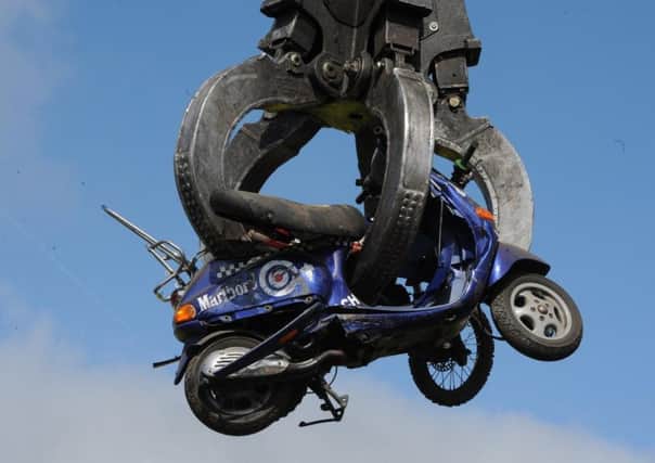 A seized off-road motorbike being crushed.