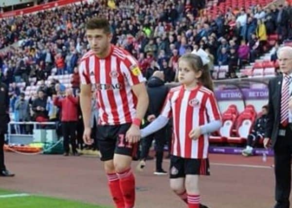 Lyden Gooch leads Nicole Agar onto the pitch when she was mascot.