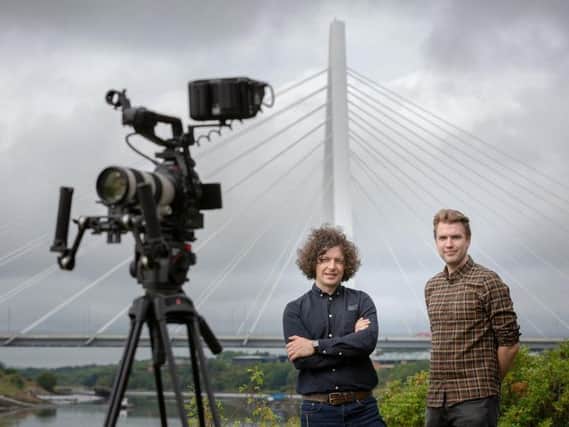 Mark Stuart Bell (left) and Glen Colledge of Second Draft with camera overlooking the Northern Spire Bridge.