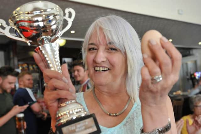 Audrey Wheatman lifts the World Egg Jarping Championship trophy.