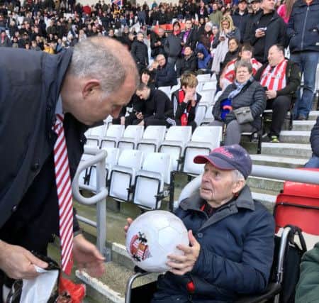 Lee Howey gives a signed football to Joseph Brazier.