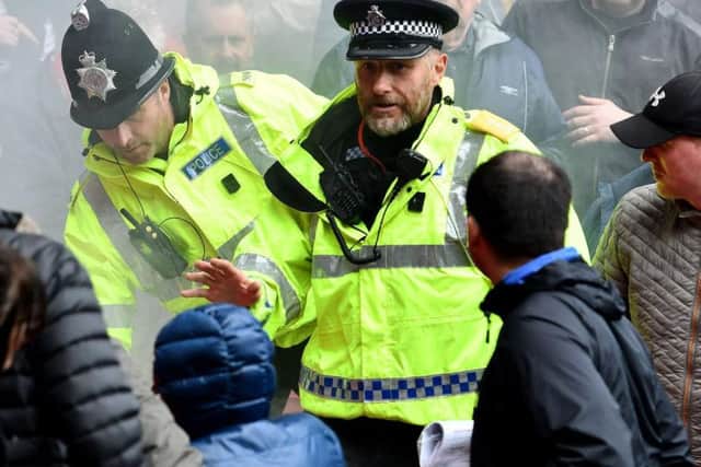 A police officer appeals for calm after a flare thrown from the Portsmouth section landed among Sunderland supporters at the Stadium of Light.