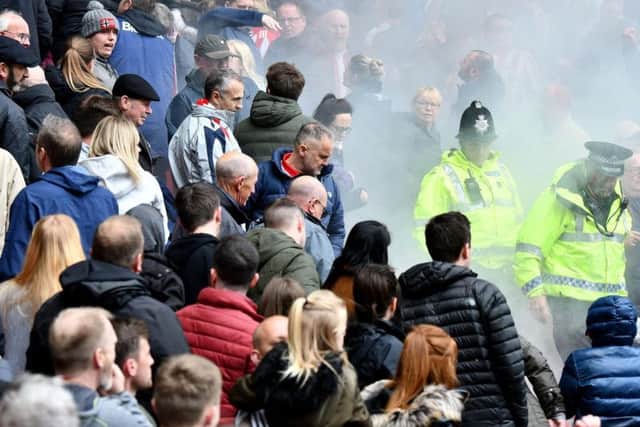 Smoke from what is believed to be a flare surrounds supporters in the lower area of the North Stand at the Stadium of Light during today's game.