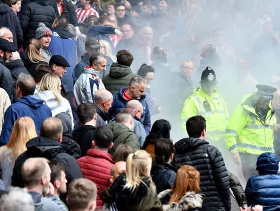 Smoke from what is believed to be a flare surrounds supporters in the lower area of the North Stand at the Stadium of Light during today's game.