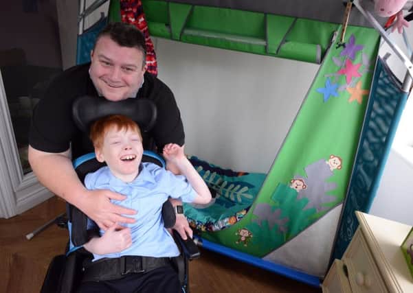 Benjamin Edmundson-Brown, 12 in his new house extension bedroom to fit his needs with step father Peter Kell.