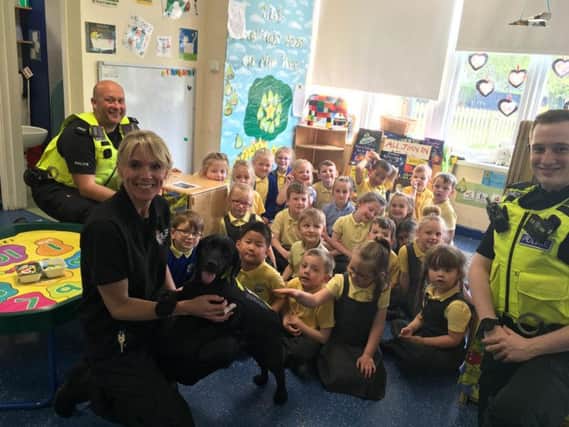PC Neill Overton, PC Dan Armstrong, police community engagement officer Sally College and community dog Russell with children at Dame Dorothy Primary School