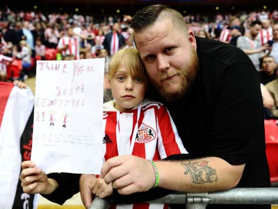 Lola McLean with her dad Dan holding her card for Sunderland player Grant Leadbitter.