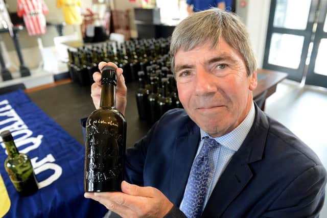 Frank Nicholson holding one of the signed   bottles