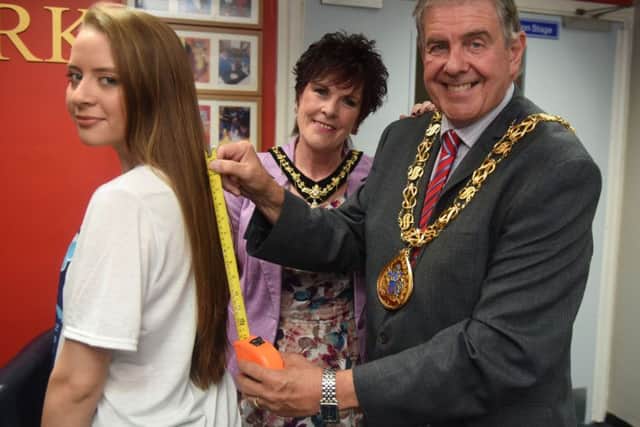 Charley Wood has her hair measured by the Mayor and Mayoress of Sunderland, Coun Barry Curran and his wife Carol, before having it cut.