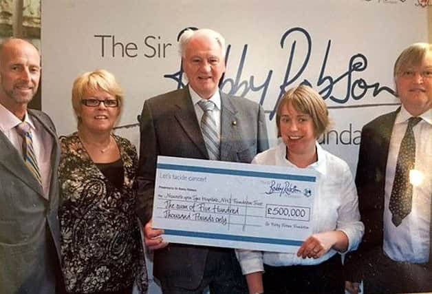 Johnny Bliss, far left, pictured with Sir Bobby Robson, centre, after the former football managers foundation broke through the £500,000 barrier.