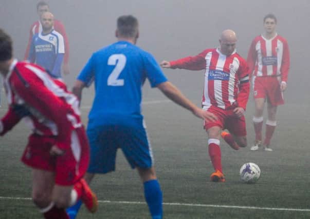 Seaham Red Star (stripes) line up a shot in last week's FA Vase defeat to Dunston UTS in the fog at Consett