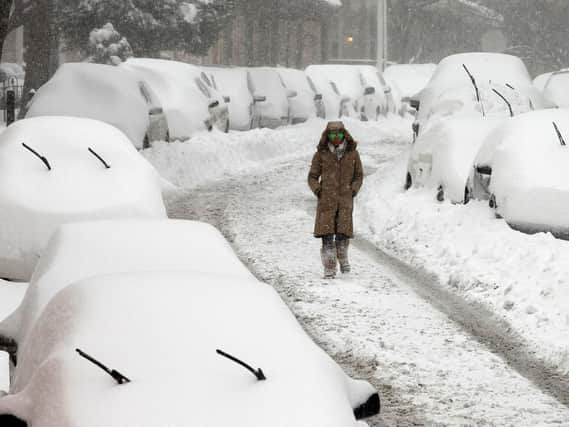 A woman walks along a street in Philadelphia, after a blizzard with hurricane-force winds brought much of the East Coast to a standstill.