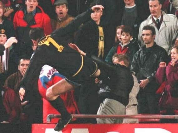 Eric Cantona launches his infamous kung-fu-style attack on a fan.