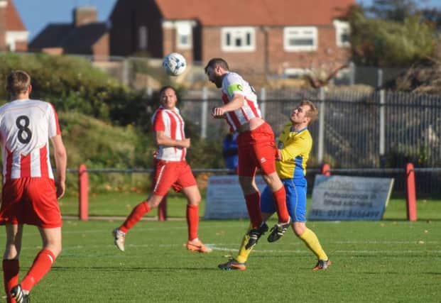 Ryhope CW skipper Phil Hall (red/white) clears against Billingham Synthonia