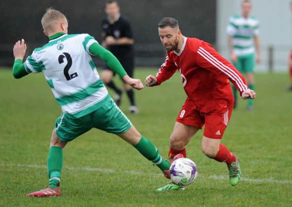 Washington striker John Butler (red) takes on West Allotment Celtic in the First Division. Picture by Tim Richardson