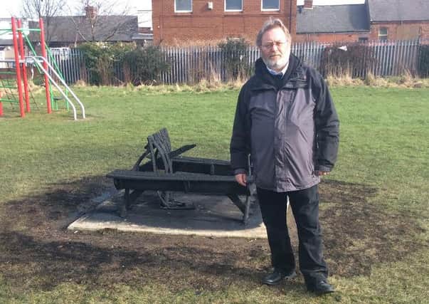Councillor Bob Price with the bench that was set alight.