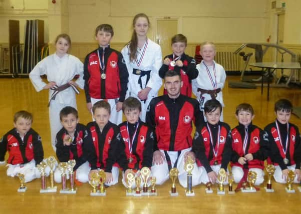 Ryhope Karate Club members with their instructor Mark Holt, centre, and the trophies they won at a arecnt competition.