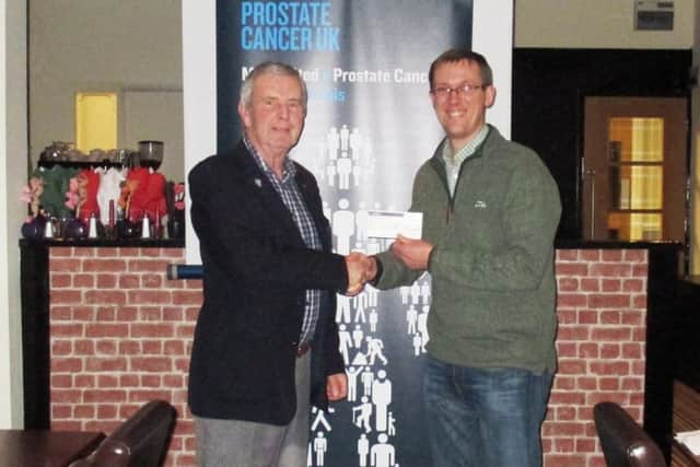 Mike Evans, from the Lions Club of Sunderland, hands a cheque to Peter Talbot in aid of Prostrate Cancer Research.