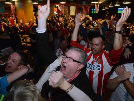 Sunderland fans celebrate Defoe's goal in a Stadium of Light sports bar.