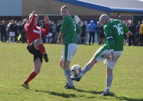 TC Plastics (red) try to block a Ryhope Railway Inn clearance in the Sunderland Sunday League's Billy Pemberton Memorial Cup final at Ford Quarry on Good Friday. Picture by Kevin Brady