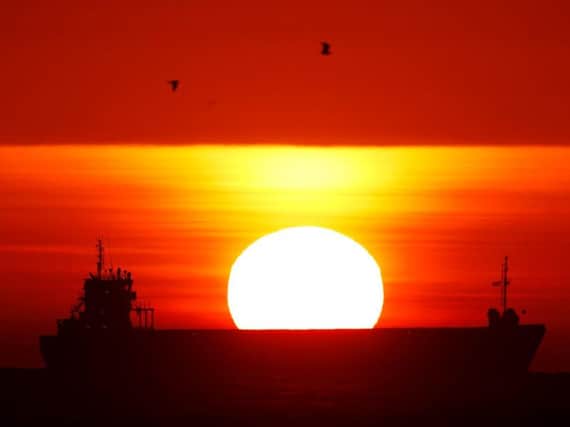 A ship out in the North Sea waits to enter the River Tyne on the North East coast as the sun rises.