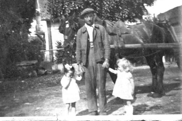 A photograph from Thomas McBride's 's own archives from his time in France. It shows Monsieur Caumont with his twin daughters Janine and Marie near Evereux.