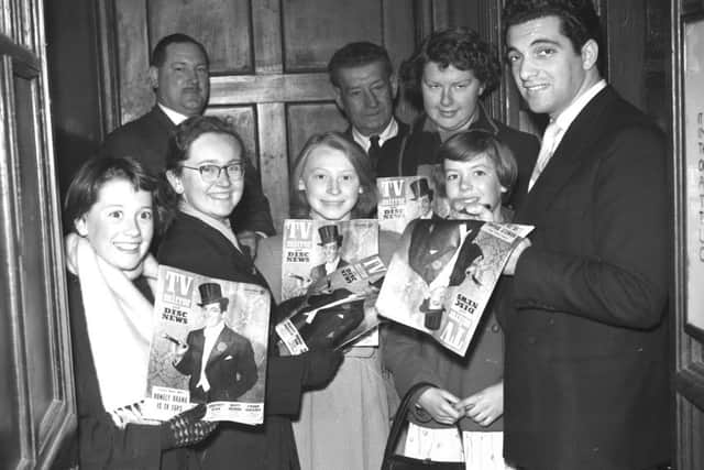 Frankie Vaughan signs autographs for his fans in doorway of the Empire.
