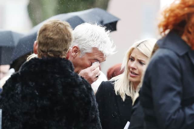This Morning presenter Phillip Schofield wipes his eye as Holly Willoughby looks on following the funeral of TV agony aunt Denise Robertson Sunderland Minster.