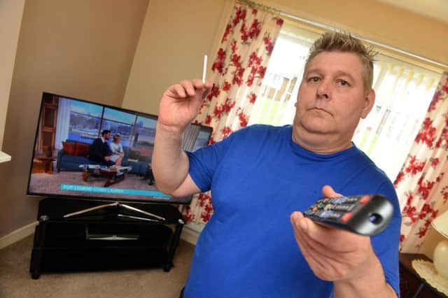 Thomas Defty with the new television set he has bought after the old one was damaged by smoke.