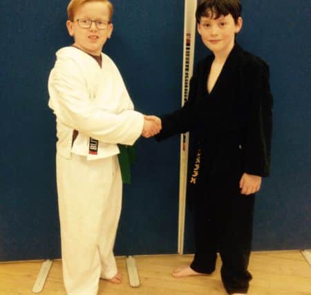 Redby Karate Club black belt Daniel Green, right, congratulates William Rostron on his achievement in a recent competition.