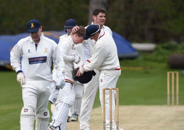 Durham Academy opener Eddie Hurst gets a pat on the head from Whitburn bower Craig Smith after he had bowled a bouncer at Hurst which hit his helmet, at Whitburn on Saturday