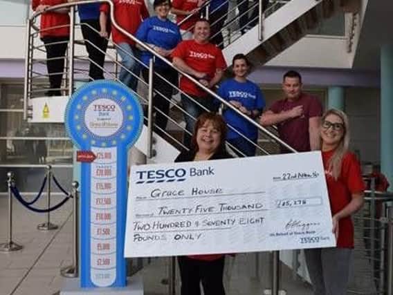 Grace House's Karen Maclennan receives a cheque for more than 25,000 from Tesco Bank.