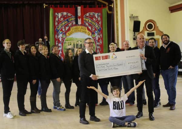 Easington Colliery Band members at the Victoria Palace Theatre where they performed in the last Billy Elliott the Musical in the West End.  They are pictured receiving a cheque for East Durham Trust wich supports former mining communities.