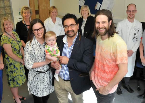 Dr Kim Henshaw holds Eloise Hoggett with her mum Samantha Jennings and dad Shaun Hoggett by his side with fellow hospital staff looking on.