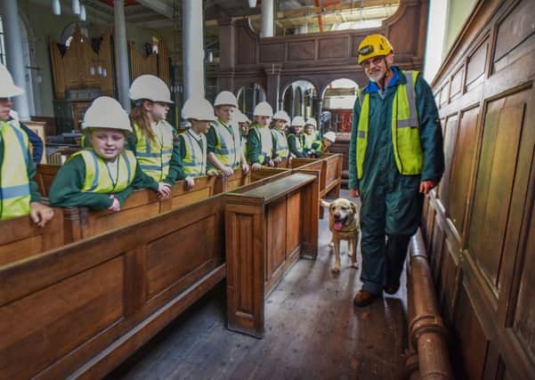 Sam the 'Rot Hound' with his handler Peter Monaghan at work in Holy Trinity Church, in Sunderland's East End, where Sam has been helping conservationists to see out dry rot and decay in Holy Trinity's woodwork. Watching are pupils from Hudson Road Primary School.