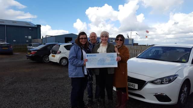 Faye accepting a cheque from EDF Energy with mum Pam, dad Terry and sister Abigail
