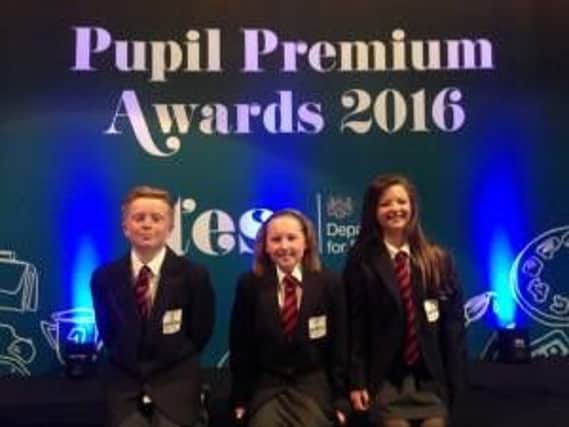 Pupils from Northern Saints CE Primary School, TJay Jones, Lauren Hair and 
Ballie Taylor, celebrate the school's national award.